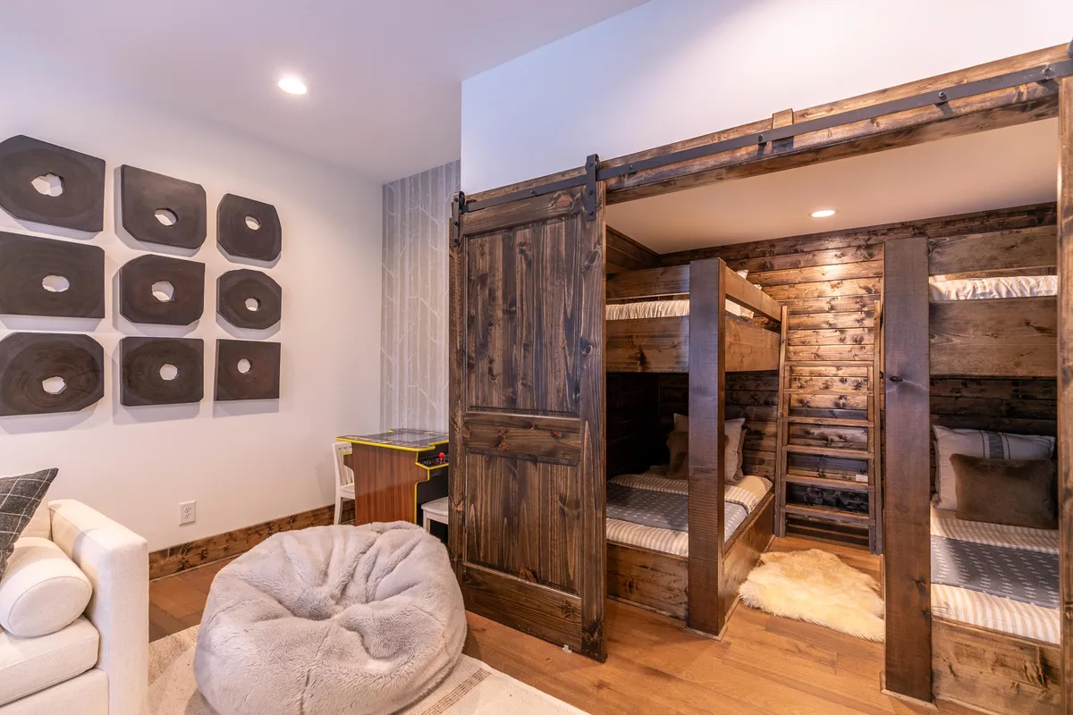 A playful and inviting bunk nook complete with cozy bunk beds, cheerful artwork, a bean bag chair, and a small play area table. The design is child-friendly and encourages both sleep and creative play.